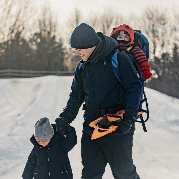 Un père et ses deux jeunes enfants au parc nature Les-Forestiers-de-Saint-Lazare en hiver