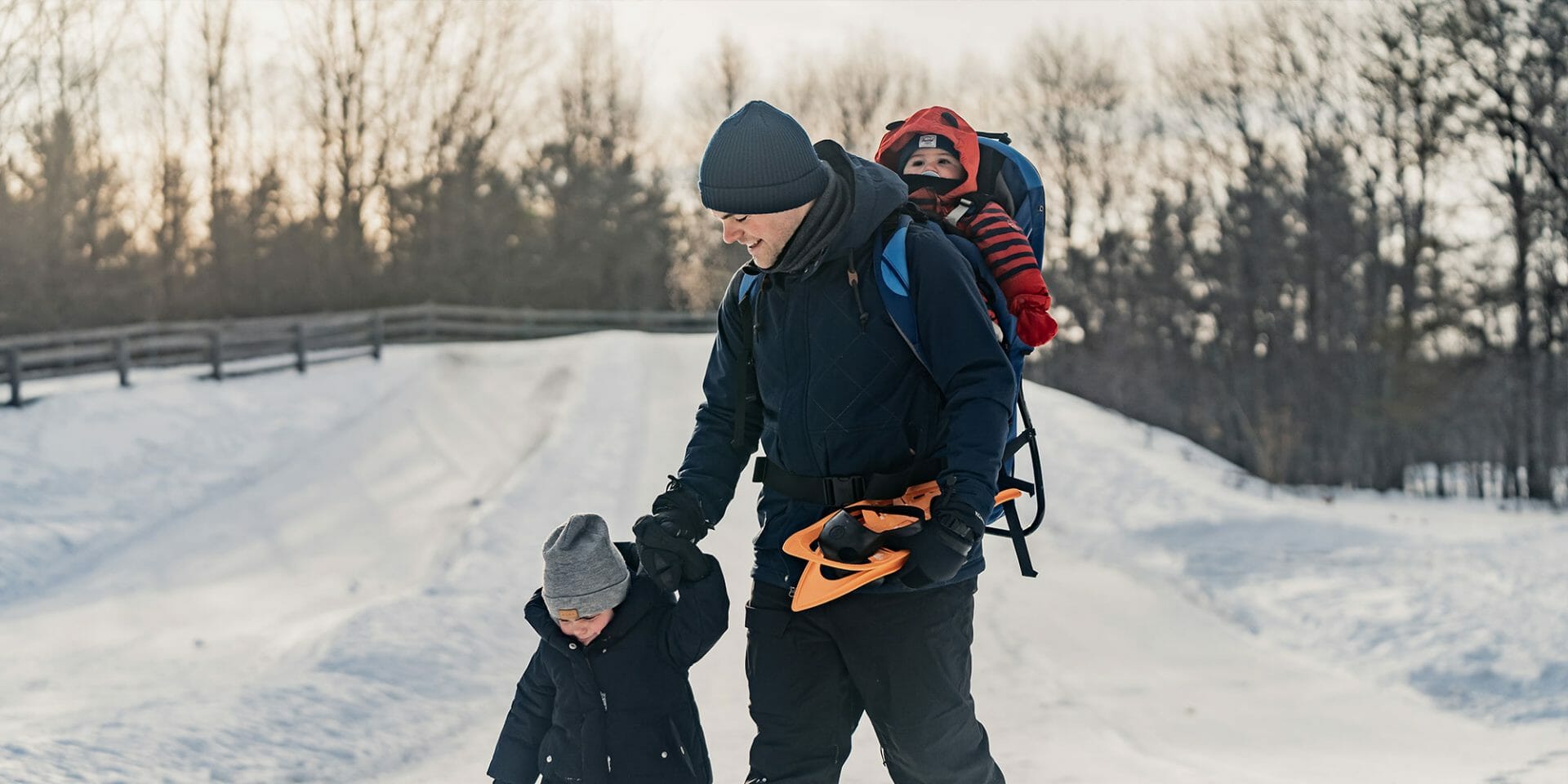 Un père et ses deux jeunes enfants au parc nature Les-Forestiers-de-Saint-Lazare en hiver