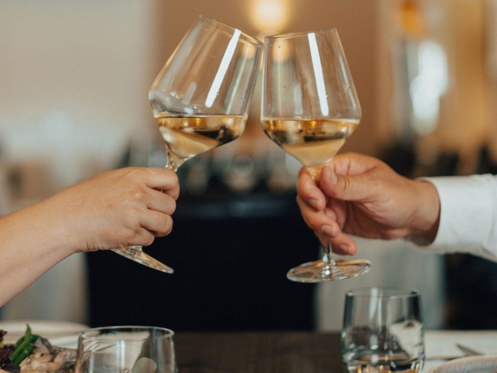 Couple levant leur verre de vin au restaurant 1171 de l'Auberge des Gallant